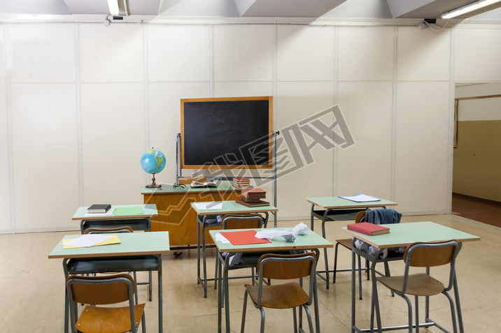 desks and blackboard in classroom at school