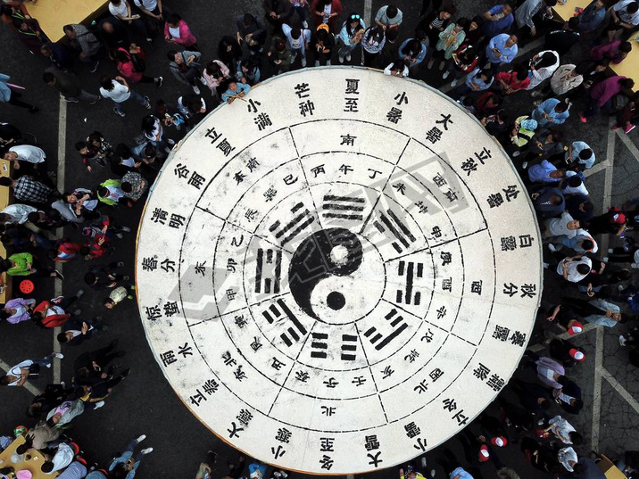 Tourists share 3.5 tons of tofu in the shape of a Tai Chi diagram during a Taoist festival at the La