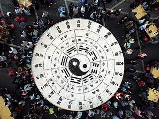 Tourists share 3.5 tons of tofu in the shape of a Tai Chi diagram during a Taoist festival at the La