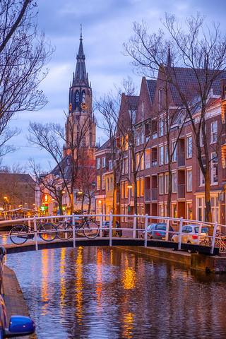 Evening view of the canal and the church in Delft near Amsterdam. Dutch city in the spring after sun