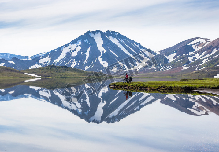 biker on backdrop of lake and mountains