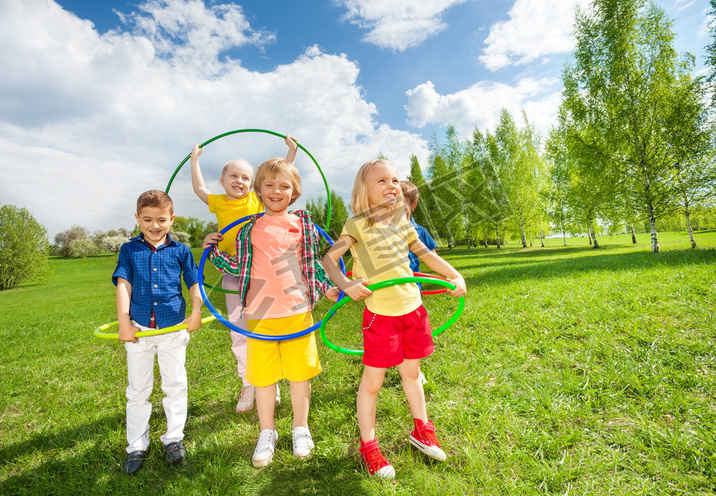 children holding hula hoops in park