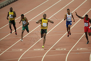 Usain Bolt of Jamaica, center, crosses the finish line to win the men's 200m final during the Beijin