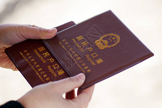 --FILE--A local Chinese resident shows his household register, also known as hukou, in Ji'nan city,