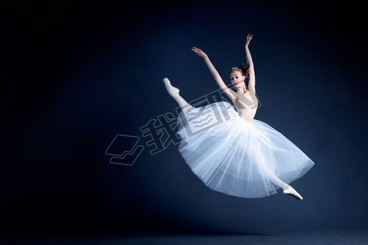 Young ballerina with a perfect body is dancing in the photostudio in different dresses