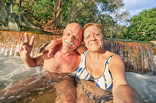 Senior happy couple taking selfie at Maquinit Hot Spring in Coron - Relax concept to Philippines won