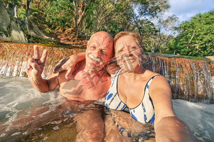 Senior happy couple taking selfie at Maquinit Hot Spring in Coron - Relax concept to Philippines won