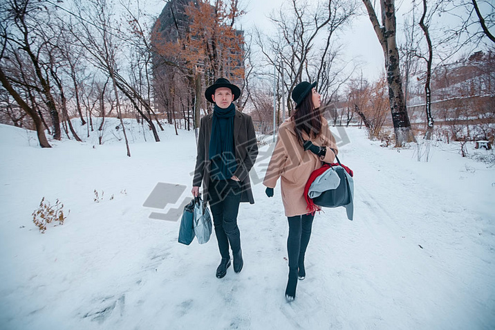 Young hipster beautiful couple in black hats in the winter forest,love,winter vacation in mountains,