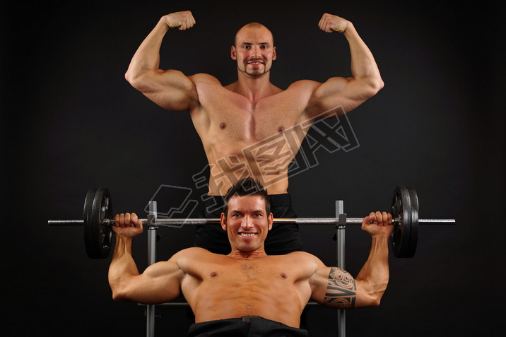 Muscular men posing with dumbbells