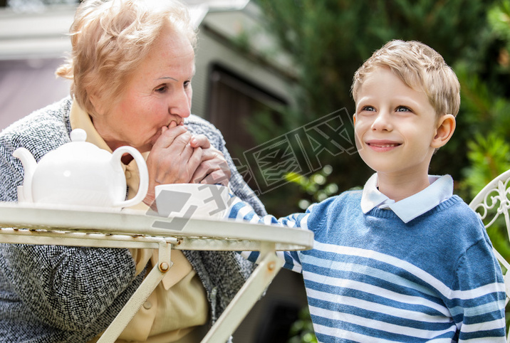 Positive grandmother and grandson spent time together in summer solar garden.