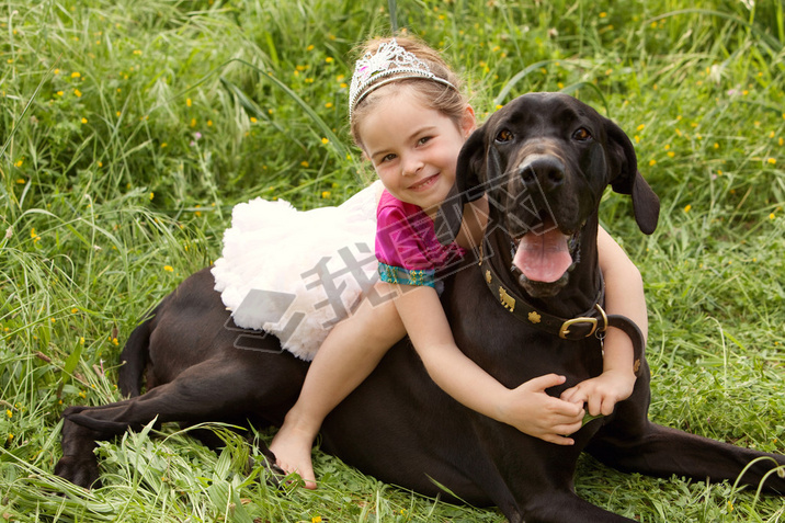 girl sitting on her dogs in a park field