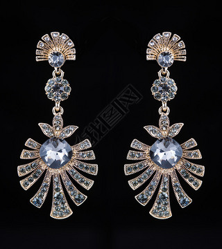 gold earrings with jewels on the black