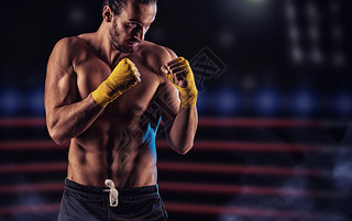 Strong muscular boxer in red boxing gloves. A man in a boxing