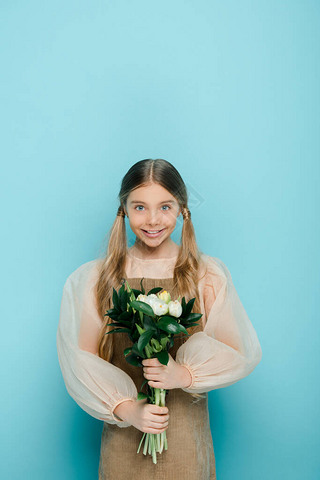 happy kid holding bouquet of flowers on blue