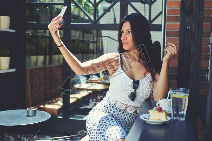 Woman making self portrait with mobile phone
