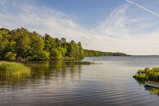 美丽的湖景,蓝天上有小船,背景白云.美丽的夏季自然背景。瑞典、欧洲.