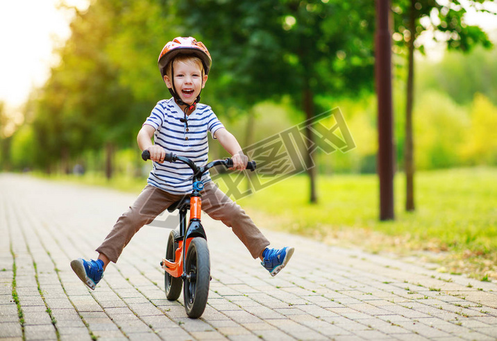 happy child boy rides a racetrack in Park in summer