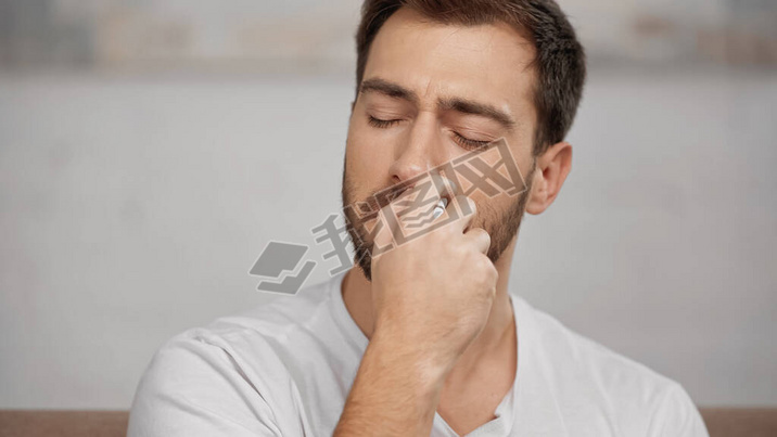 allergic man in white t-shirt using nasal spray at home 