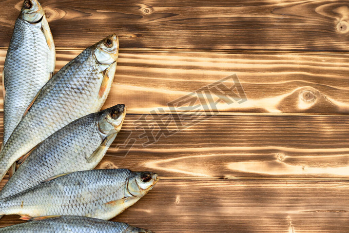 dry fish on a wooden background with space for text