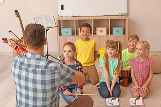 Teacher giving music lessons at school