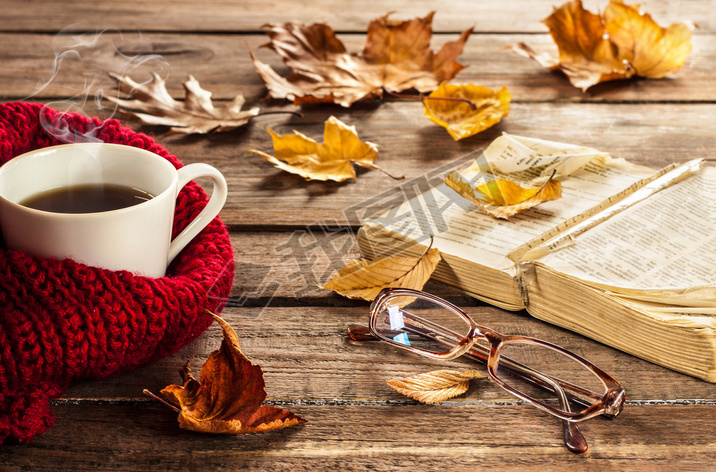 Hot coffee, vintage book, glasses and autumn lees on wood