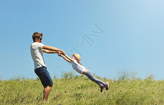 Father and daughter spinnig outdoor