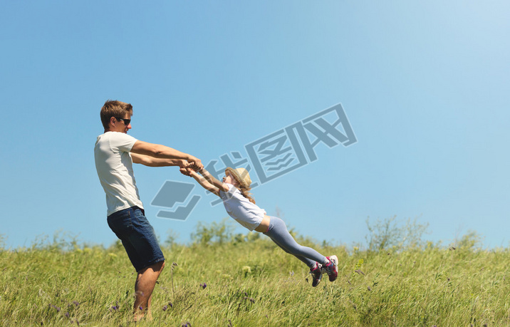 Father and daughter spinnig outdoor