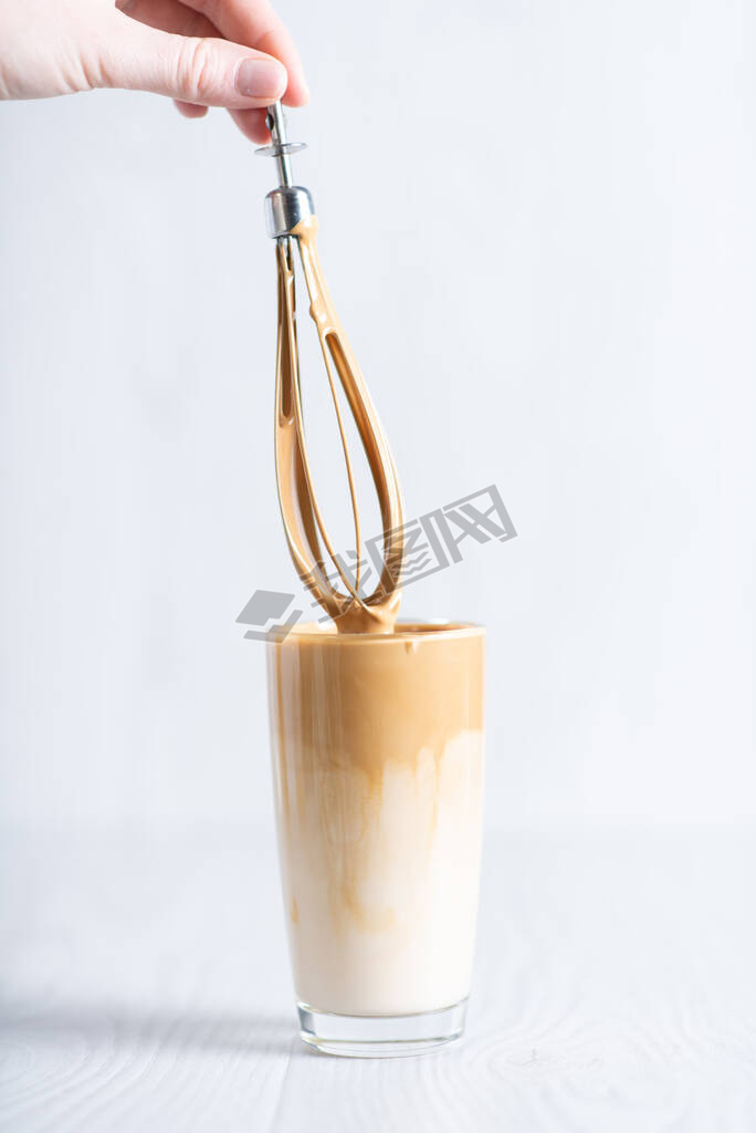 Korean fluffy creamy whipped coffee. Cold dalgonacoffee coffee in a glass on a light background. Ice