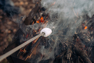 Marshmallow grilling on bonfire, oke and heat from fire