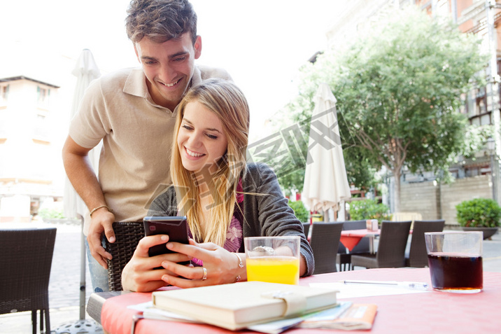 couple using a artphone at cafe