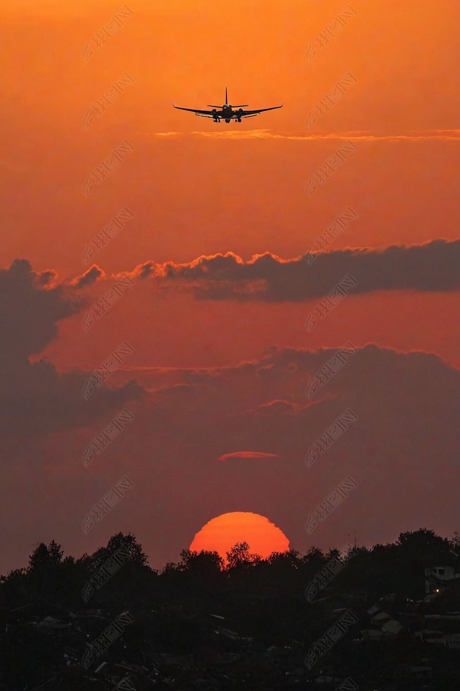 原创落日夕阳下一驾飞机飞越被晚霞烧红天空-版权可商用