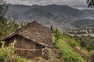 Wooden shed farmers in highlands of China, amid rice fields.