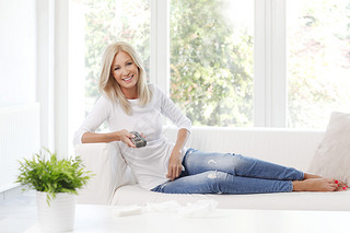 female holding remote controll and watching tv