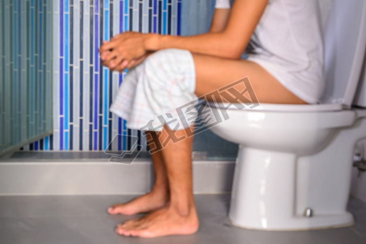 Blurred man defecating in private toilet. 