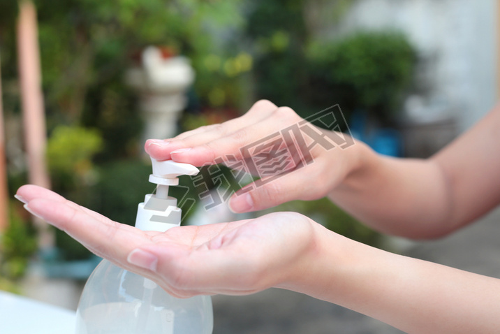 Female hands using gel pump dispenser wash hand sanitizer.