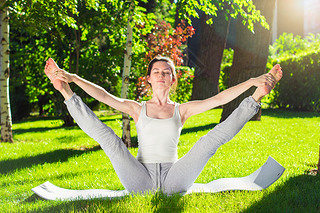 Young woman doing yoga in the park in the morning