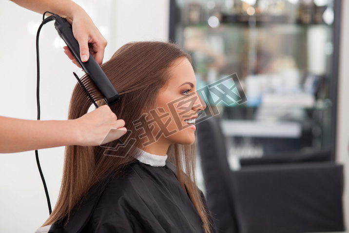 Experienced young hairstylist is serving her customer