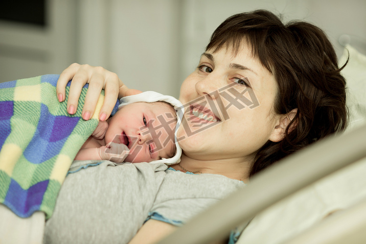 happy woman after birth with a newborn baby