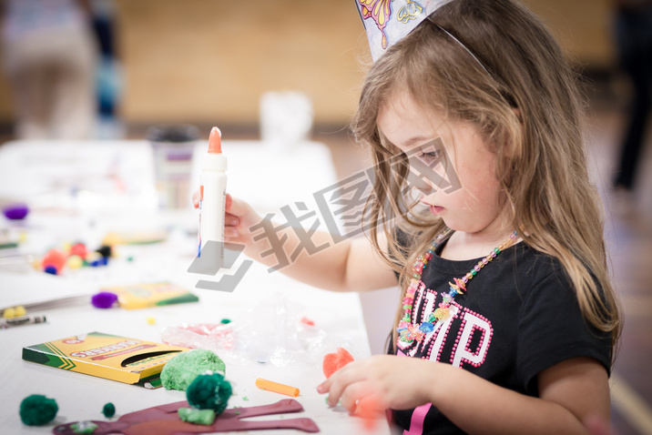 little girl making handcraft at a table