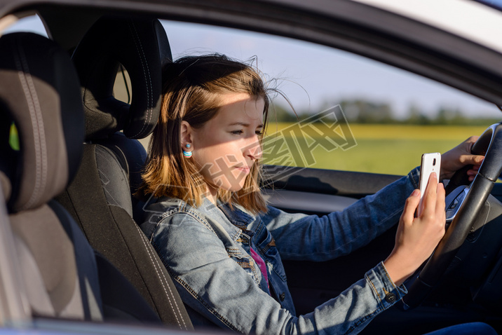 Young female driver reading a text message