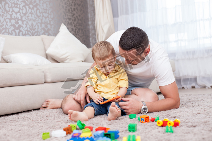 Cheerful young man is playing with his kid