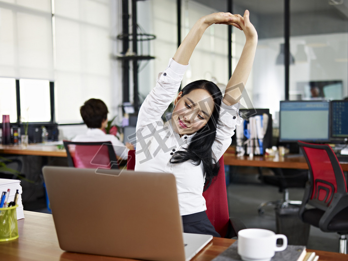 asian business woman stretching arms in office