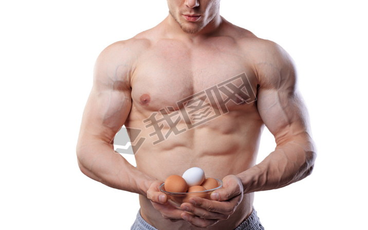 Shirtless athlete man showing cup with eggs at isolated white background