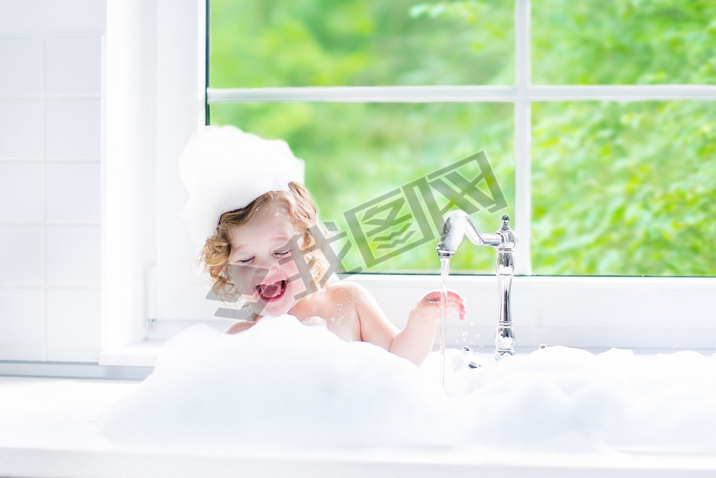 Baby girl taking bath with foam