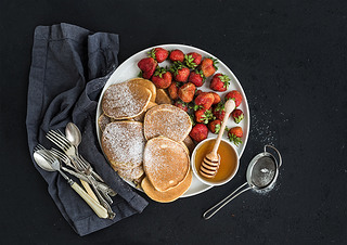 Breakfast plate. Homemade pancakes with fresh strawberry and honey, kitchen napkin, vintage silverwa