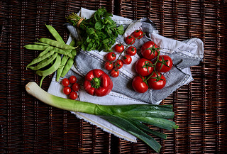 There are vegetables on a dark rattan table