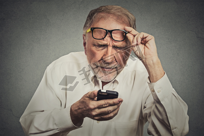 elderly man with glasses hing trouble seeing cell phone
