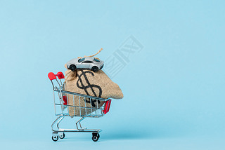 little shopping trolley with dollar bag and toy car on blue, leasing concept