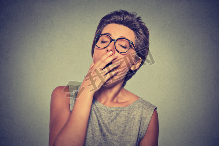 headshot sleepy young woman with hand over open mouth yawning