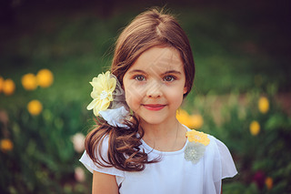 summer outdoor portrait of adorable iling kid girl with yellow flowers on background